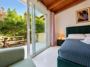 a bedroom with a bed and a sliding glass door at Sun Arise in Porto Rafti