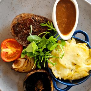 a plate of food with eggs and a cup of sauce at Burlington Berties in Sheringham