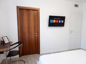a room with a bed and a desk and a door at OverGarden Rooms in Dossobuono