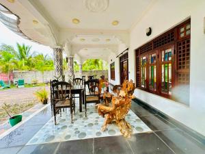 a living room with a table and chairs on a house at Cleopatra villa in Kattankudi