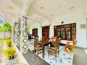 a dining room with a wooden table and chairs at Cleopatra villa in Kattankudi