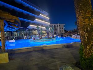 a swimming pool in front of a building at night at Liberty S Hotel in Novalja