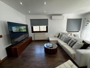 a living room with a couch and a flat screen tv at Villa Retreats in Santa Eularia des Riu