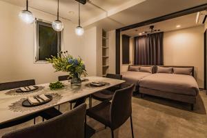 a living room with a bed and a table and chairs at SLL Urban Suites Ebisu in Tokyo