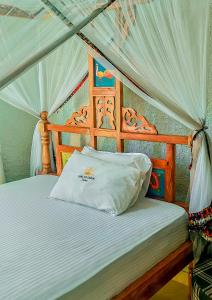 a bed with a canopy with a white pillow on it at King Solomon Hotel in Nkunjila