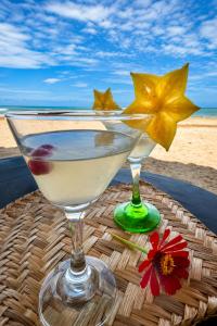 two wine glasses sitting on a table near the beach at Coccoloba Beach Hotel in Dibulla
