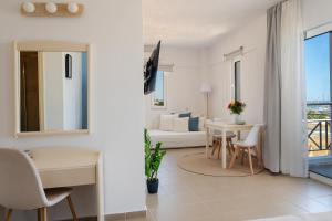 a white room with a bed and a table and chairs at Thalyra in Rethymno