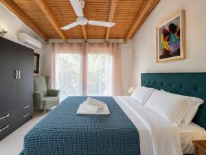 a bedroom with a bed and a ceiling fan at Sun Arise in Porto Rafti