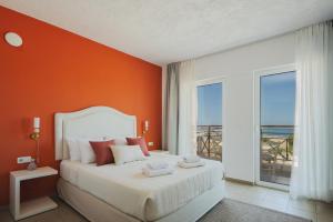 a bedroom with a large bed with an orange wall at Thalyra in Rethymno