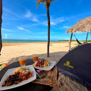 two plates of food on a table on the beach at Coccoloba Beach Hotel in Dibulla