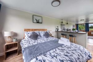 a bedroom with a bed with a blue and white comforter at Farmer's Cabin in Forfar