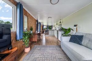 a living room with a couch and a kitchen at Farmer's Cabin in Forfar