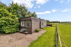 a tiny house in a field with a fence at Farmer's Cabin in Forfar