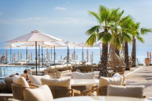 a resort with a pool and chairs and palm trees at Medite Kassandra Resort in Nea Moudania