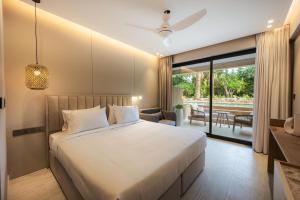 a bedroom with a large bed and a patio at Medite Kassandra Resort in Nea Moudania