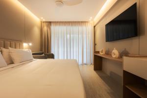 a hotel room with a bed and a television at Medite Kassandra Resort in Nea Moudania