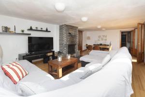 a living room with two white couches and a fireplace at Casa El Mirador de Jaca in Jaca