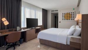 a hotel room with a bed and a desk with a computer at Holiday Inn Acapulco Amarea by IHG in Acapulco