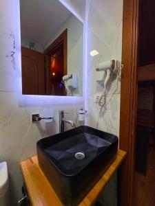 a bathroom with a black sink and a mirror at Guest House Hasko in Gjirokastër