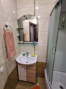 a bathroom with a sink and a shower and a mirror at затишна квартирка in Kremenchuk