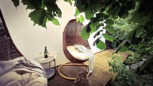 a room with a rattan chair and a cat on a deck at Vinoteegi Residents in Kuressaare