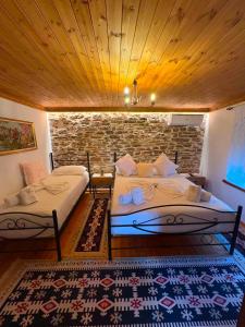 a bedroom with two beds and a brick wall at Guest House Hasko in Gjirokastër