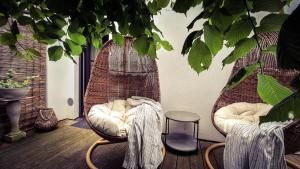 a porch with two wicker chairs and a table at Vinoteegi Residents in Kuressaare