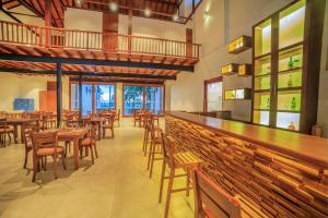 a restaurant with a bar with wooden tables and chairs at R Degrees in Ambalangoda