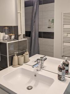 a bathroom with a white sink and a mirror at Cocoon studio in Gap