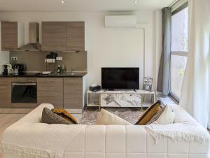 a living room with a white couch and a kitchen at Cocoon studio in Gap