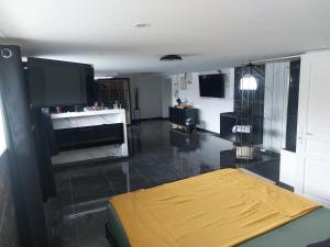 a living room with a yellow bed and a television at Suite Privée Deluxe O'Palawan Gold PROCHE TOURCOING CENTRE in Tourcoing
