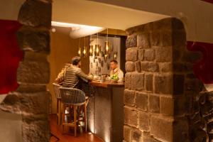 two men sitting at a bar in a restaurant at Casa Cartagena Boutique Hotel & Spa in Cusco