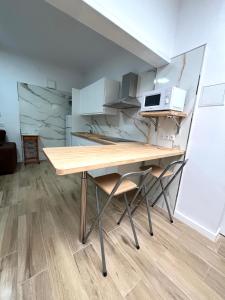 a kitchen with a wooden table and two chairs at Teror Centro 1 in Teror