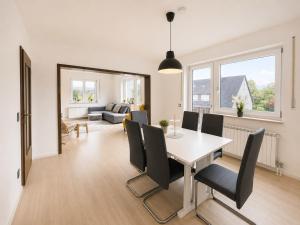 a dining room and living room with a table and chairs at Dill Apartments Pleinfeld Pacellistraße in Pleinfeld +11 photos