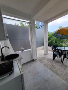 a kitchen with a patio with a table and a umbrella at stockholm in Bregvija