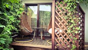 a wooden deck with two chairs and a table at Vinoteegi Residents in Kuressaare