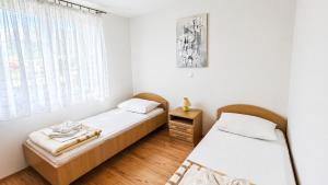 two twin beds in a room with a window at Apartments Mia in Baška