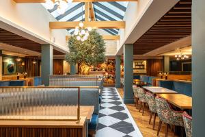 a restaurant with tables and chairs and a large skylight at Bunratty Castle Hotel & Leisure Club, BW Premier Collection in Bunratty