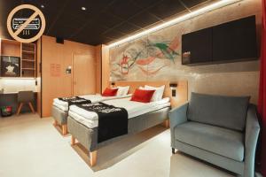 ein Schlafzimmer mit einem Bett und einem Stuhl in der Unterkunft Time Hotel, Time To Stay art & boutique in Jyväskylä