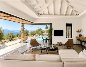 a living room with a white couch and a tv at Villa Melisea in Sfendoúrion