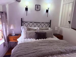 a bedroom with a large bed with pillows at Brewhouse Cottage 18th Century Cottage -Three Peaks Settle in Settle