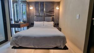 a bedroom with a large white bed in a room at Luxury Fairland Fully Serviced Cottages in Johannesburg
