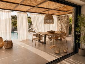 an outdoor dining room with a table and chairs at Villa Melisea in Sfendoúrion