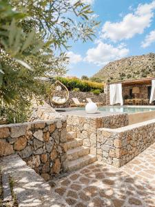 a villa with a swimming pool and a stone wall at Villa Melisea in Sfendoúrion