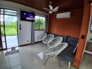 a living room with four chairs and a couch at Perla Arenal View in Fortuna
