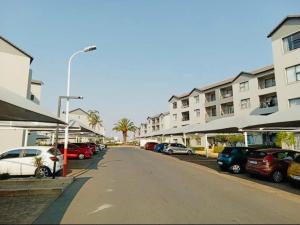 a street with cars parked on the side of a building at Cozy getaway in Midrand