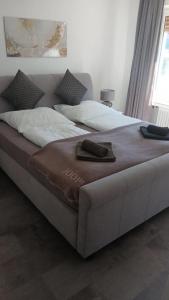 a large bed with a brown blanket on top of it at Kontinental A in Bad Harzburg