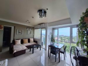 a living room with a couch and a table at De Luxe, Standard and Studio Suites -The Breeze Residences-close to Airport,Mall of Asia, US Embassy in Manila