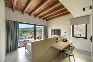a bedroom with a bed and a desk in a room at KHAI Syvota in Syvota