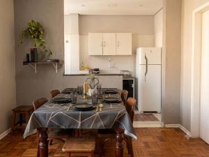 a kitchen with a table and a white refrigerator at Apto Gonzaga a 20m da praia -Ar Split & Pet Friendly in Santos